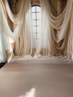 an empty room with sheer drapes on the windowsill and carpeted flooring