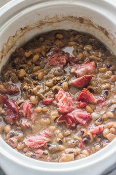 a white crock pot filled with beans and ham