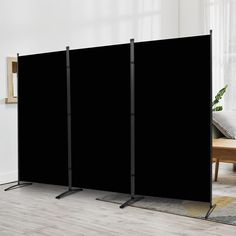 three black screen dividers in front of a couch