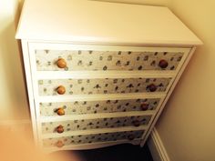 a white dresser with lots of drawers and knobs