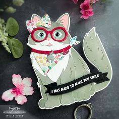 a close up of a paper cut out of a cat with glasses and a ribbon