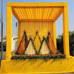 an outdoor stage decorated with flowers and curtains