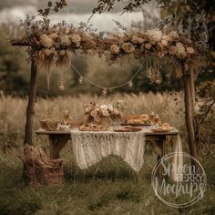 an outdoor table with flowers and candles on it in the middle of a grassy field