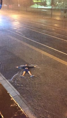 a person laying on the ground in the rain