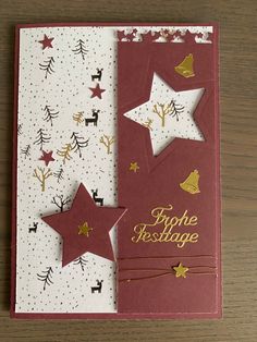 a red and white christmas card with gold stars