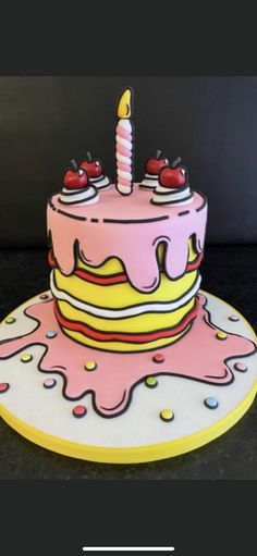 a pink and yellow birthday cake sitting on top of a table