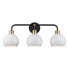 three light bathroom fixture in an antique brass finish with white glass globe shades and black metal arm