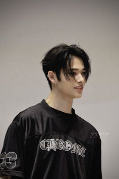 a young man with black hair wearing a black shirt