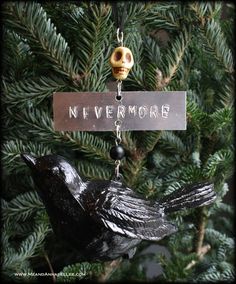 a black bird ornament hanging from a tree with a sign that says nevermore