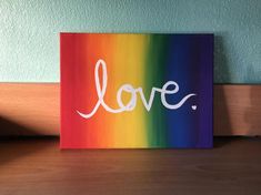 a colorful painting with the word love painted in white on it's bottom corner