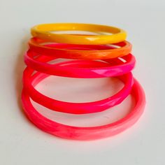 Vintage collection of plastic bangle bracelets. These are so fun. Light weight. Bright sherbert colors in pinks, orange and yellow. They measure: diameter about 3.25" total and about 2.5 interior. One is smaller than the rest at this measurement. They have a subtle diamond shape on the exterior. They show very minor age or wear. Fun set. Sold as a collection together only. Shipping is included in the price. (Shipping may be listed as free- but of course its not really free...) We believe in transparency and honesty even in marketing and want you to know we are just including shipping in your purchase price.  We use USPS ground mail when ever possible. If you need an International quote or faster shipping send over a message with details and we will get you a quote. We love being able to sa Cheap Rainbow Colored Plastic Stretch Bracelet, Plastic Bangles, Tacoma Wa, Orange And Yellow, Bracelet Collection, Diamond Shape, Bangle Bracelet, Diamond Shapes, Want You