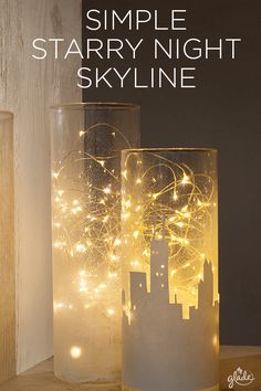 two glass vases with fairy lights in them