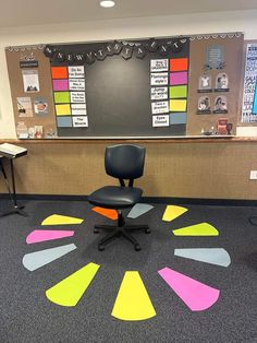 an office area with chairs, desks and bulletin board