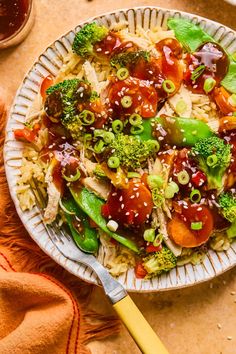 a bowl filled with rice and vegetables on top of a table