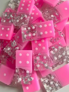 some pink and white soaps are on a table with silver flakes around them