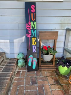 a sign that says summer is next to some potted plants and a planter