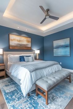 a bedroom with blue walls and white bedding has a large painting on the wall