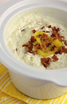 a white bowl filled with some type of food on top of a yellow and white towel