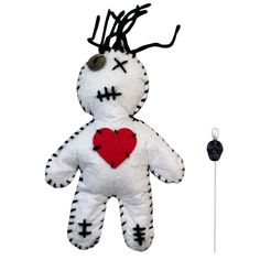 a white stuffed animal with a red heart on it's chest next to a hook