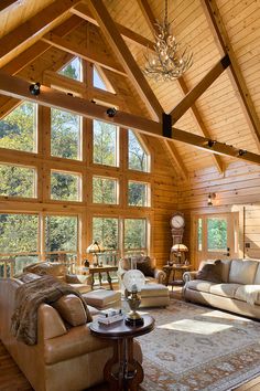 a living room filled with lots of furniture under a large window covered in wood planks