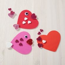 three heart shaped paper cutouts with hearts on them, one is pink and the other is red