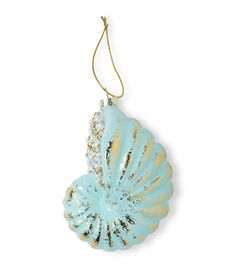 a blue and gold shell ornament hanging from a chain on a white background