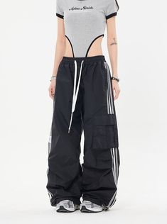 Our Striped Wide Leg Track Pants combine classic style with a relaxed fit for effortless comfort. Made with an elastic drawstring waistband and a striped pattern, these pants are perfect for weekend lounging at home or a casual day out. Model is 5'2 100lbs wearing M Techwear Design, Grunge Outfits Black, Streetwear Techwear, 90s Fashion Grunge Outfits, Iconic Y2k, Wide Leg Joggers, Cargo Sweatpants, Modern Streetwear, Y2k Women