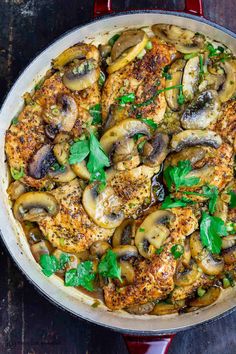 a skillet filled with chicken, mushrooms and herbs