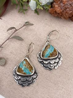 Beautiful Royston Ribbon Turquoise are accentuated by layered feathers with stamped pattern in sterling silver. Shaded patina highlights the design in these unique earrings. Sterling Silver Royston Ribbon Turquoise 1.25” long, 1.” wide Artisan Turquoise Etched Jewelry, Etched Turquoise Sterling Silver Jewelry, Artisan Etched Turquoise Jewelry, Unique Turquoise Patina Earrings, Unique Turquoise Earrings With Patina, Sterling Silver Patina Earrings, Hand Tooled Bohemian Sterling Silver Jewelry, Elk Ivory Jewelry, Turquoise Feather Earrings