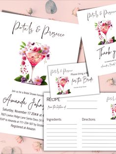 the wedding stationery is laid out on top of each other, with pink flowers and greenery