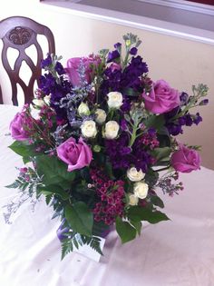 a vase filled with purple and white flowers