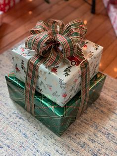 three wrapped presents are stacked on top of each other with bows and ribbons around them