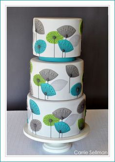 three tiered cake decorated with blue and green leaves