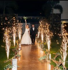 a bride and groom are walking down the aisle with their arms in the air as they exit