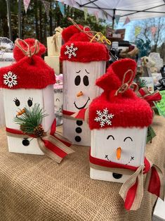 three snowmen made out of wooden blocks on a table