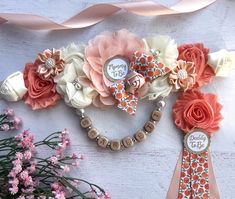 a bunch of flowers that are next to some ribbon and buttons on a table with pink flowers