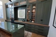 an office with gray cabinets and glass desk