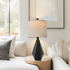 a living room scene with focus on the table lamp and white couch in the background