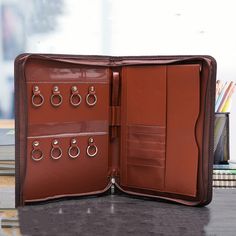 an open brown leather case with several pairs of earrings on the front and back side