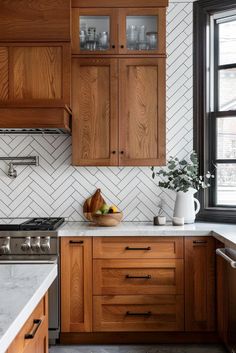 a kitchen with wooden cabinets and marble counter tops, along with a white tiled backsplash