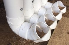 several white pipes are lined up on the ground