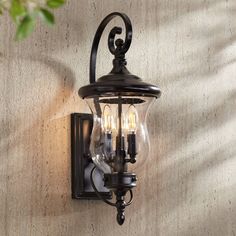 an outdoor wall light with three lights attached to it's side and on the wall