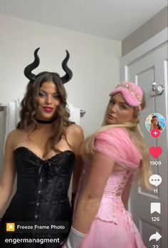 two women dressed up in costumes standing next to each other with horns on their heads