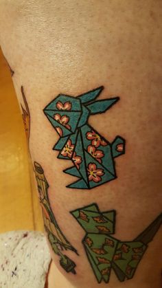 a close up of a person's leg with an origami tattoo on it