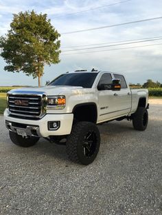 a white truck parked on top of a gravel road