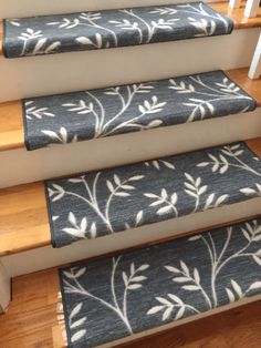 the stairs are decorated with blue and white floral rugs, along with wooden handrails