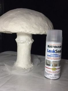 a white mushroom sitting on top of a table next to a bottle of glue and a tube