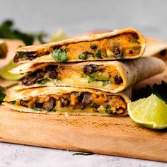 three quesadillas stacked on top of each other with cilantro and lime wedges