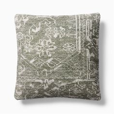 a green and white pillow with an intricate design on the front, sitting against a white background