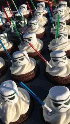 star wars cupcakes with white frosting and straw sticks sticking out of them